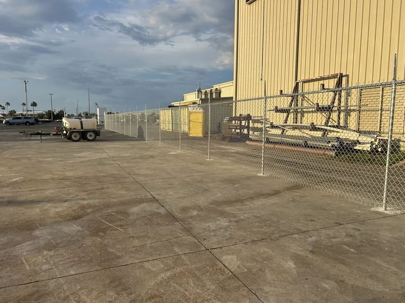 Long straight galvanized chain link fence along a warehouse in Panama City