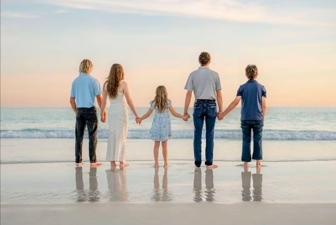 Joshua Glover's kids holding hands at the shoreline on Panama City Beach