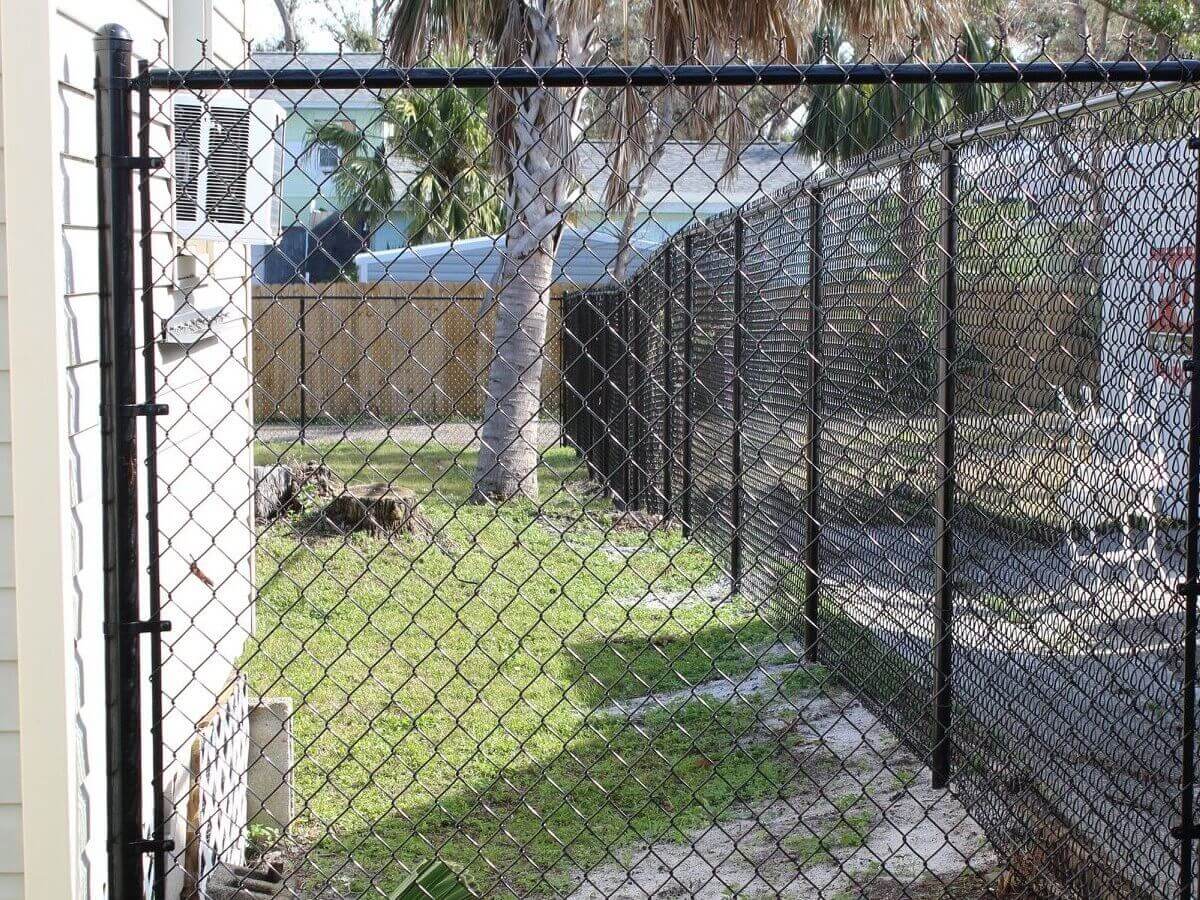Black vinyl-coated chain link fence along a residential backyard in the Panama City area