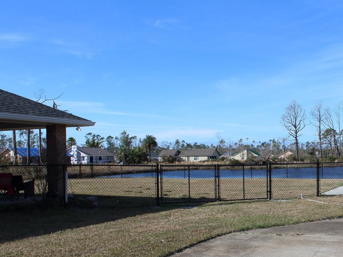 Black chain link fence along a waterfront yard