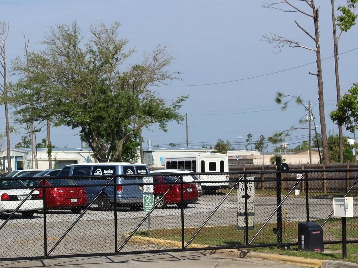 Commercial black chain link fence with a double-drive gate around a parking yard in the Panama City area