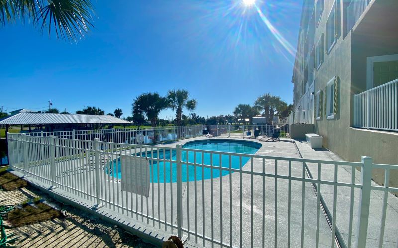 White aluminum pool safety fence around a swimming pool at a multi-story residential property