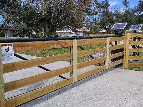 Wood ranch-style automatic slide gate across a driveway