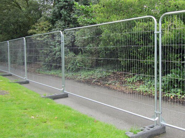 Temporary construction fence panels on stands