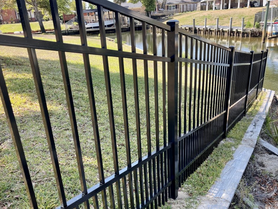 Black aluminum fence stepping down a sloped yard