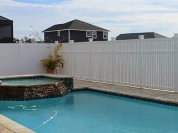 White vinyl privacy fence around a pool and spa