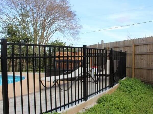 Black aluminum fence around a backyard pool