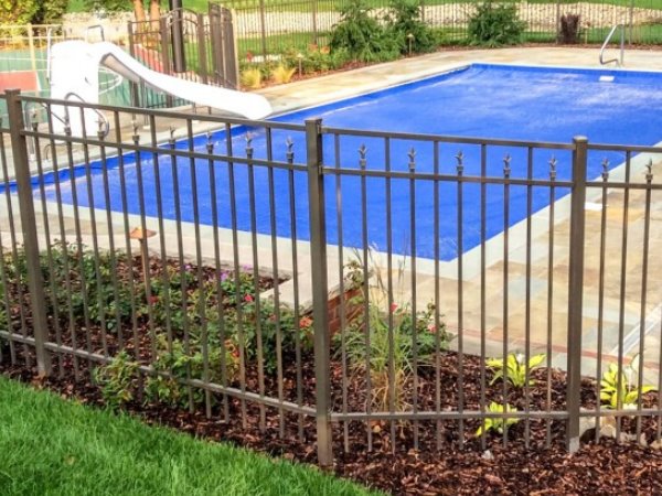 Bronze aluminum picket pool fence installed by Mr. Fence of Florida around a Panama City area backyard pool with paver deck