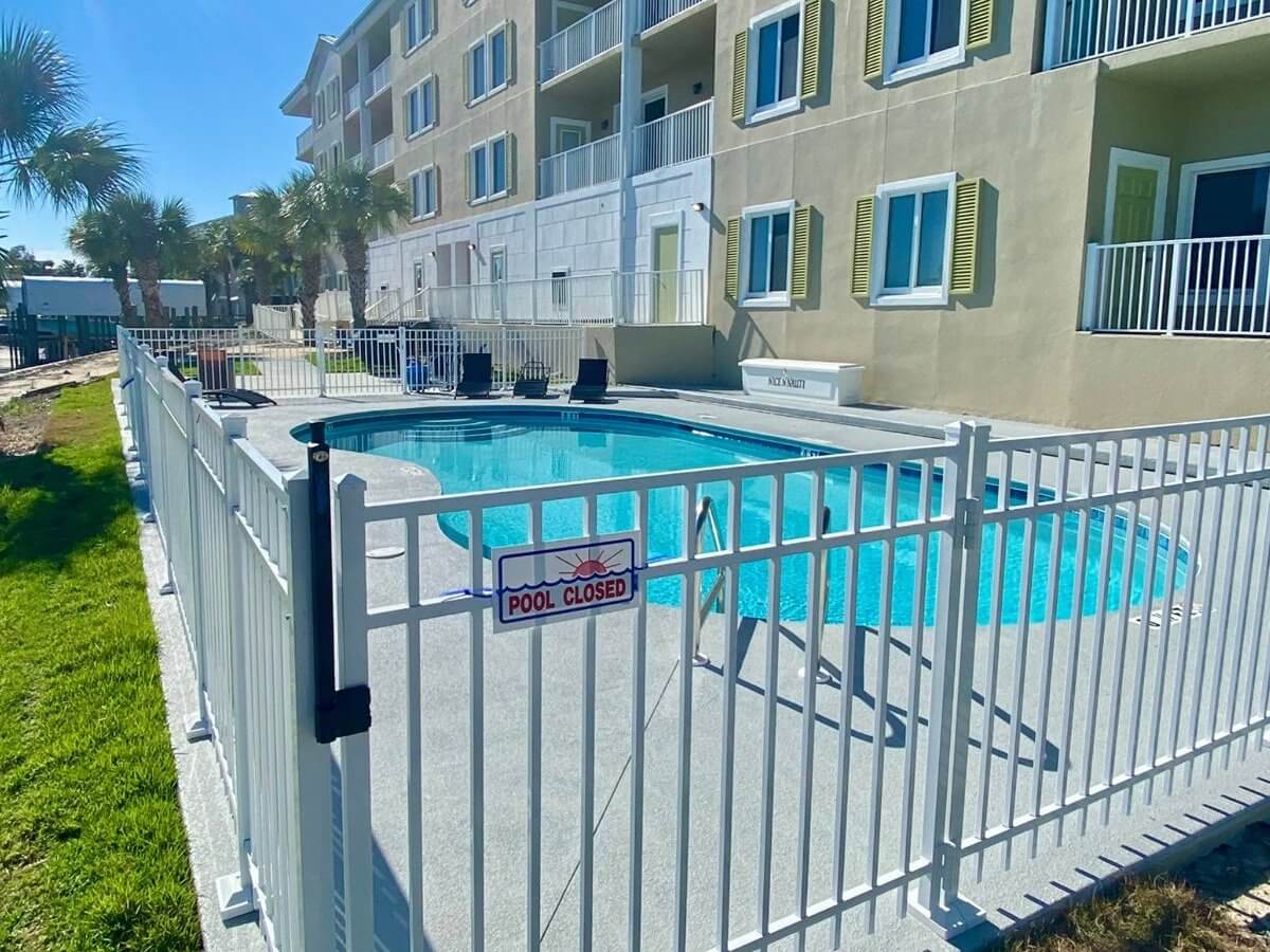 Black aluminum fence around a condo pool