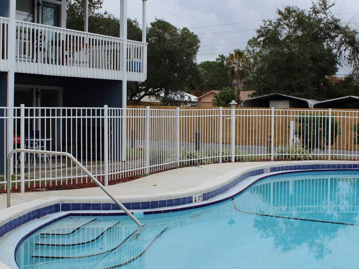 White aluminum fence around a resort pool