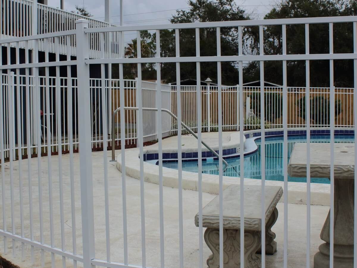White aluminum pool fence at a community pool