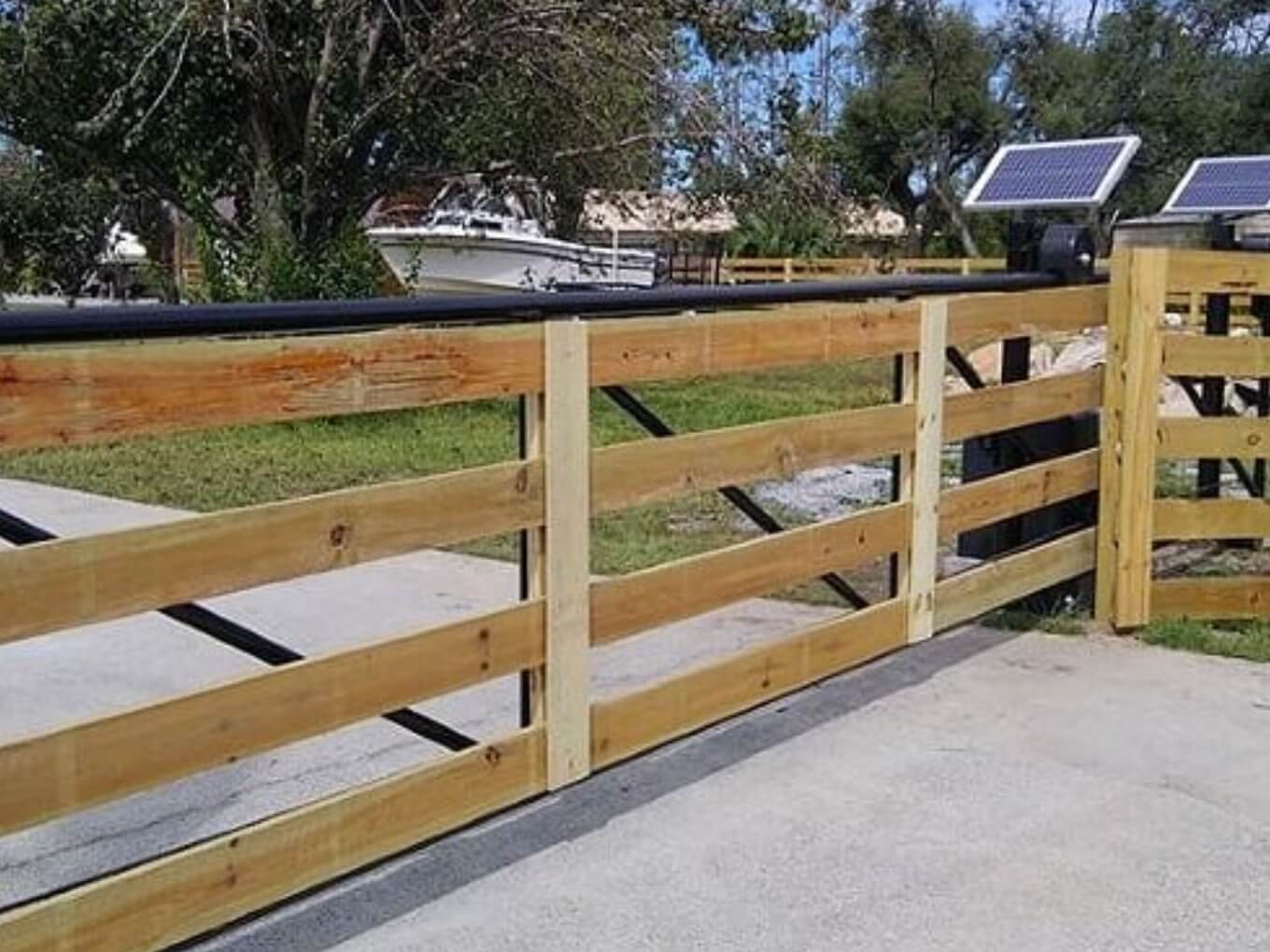 Horizontal light-wood planks set in a black metal frame beside a concrete driveway